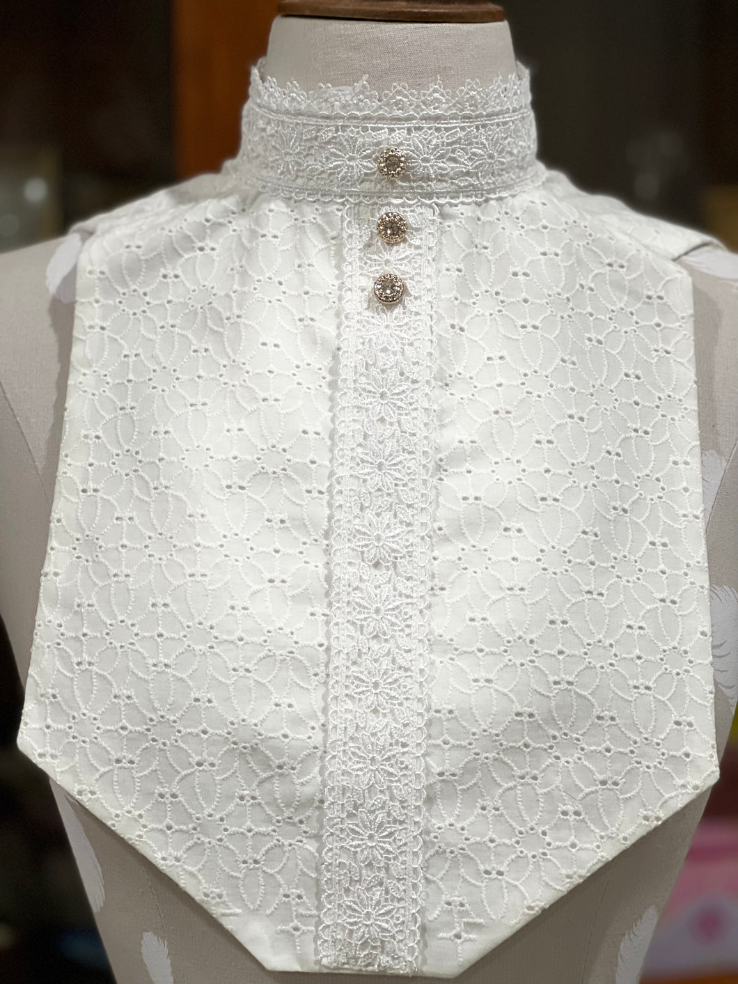 Embroidered floral and lace bib with rose gold and “diamond” buttons